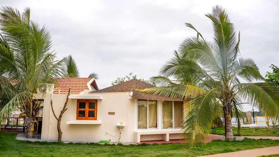 Image of a villa amidst a lawn and palm trees