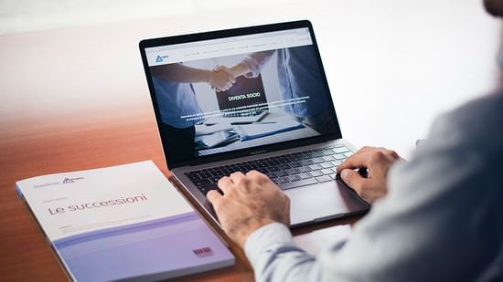 a man using a laptop for business purpose with a file next to him