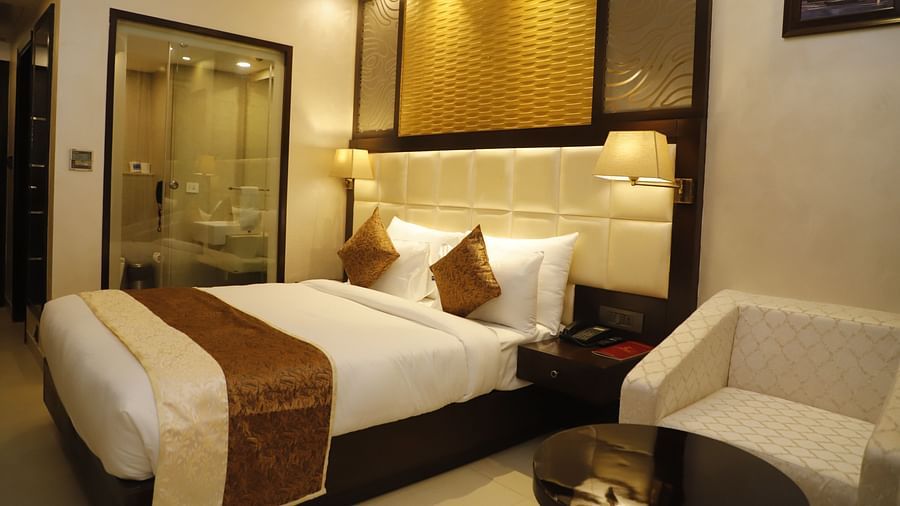 Superior Room with plush bed and a sitting space next to it