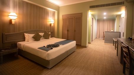  A suite at Shilton International, Kochi, with a large bed, sitting area, and ample storage.