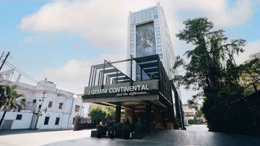 Exterior view of the Gemini Continental hotel, featuring a modern high-rise building with a large mural and a prominent entrance sign.