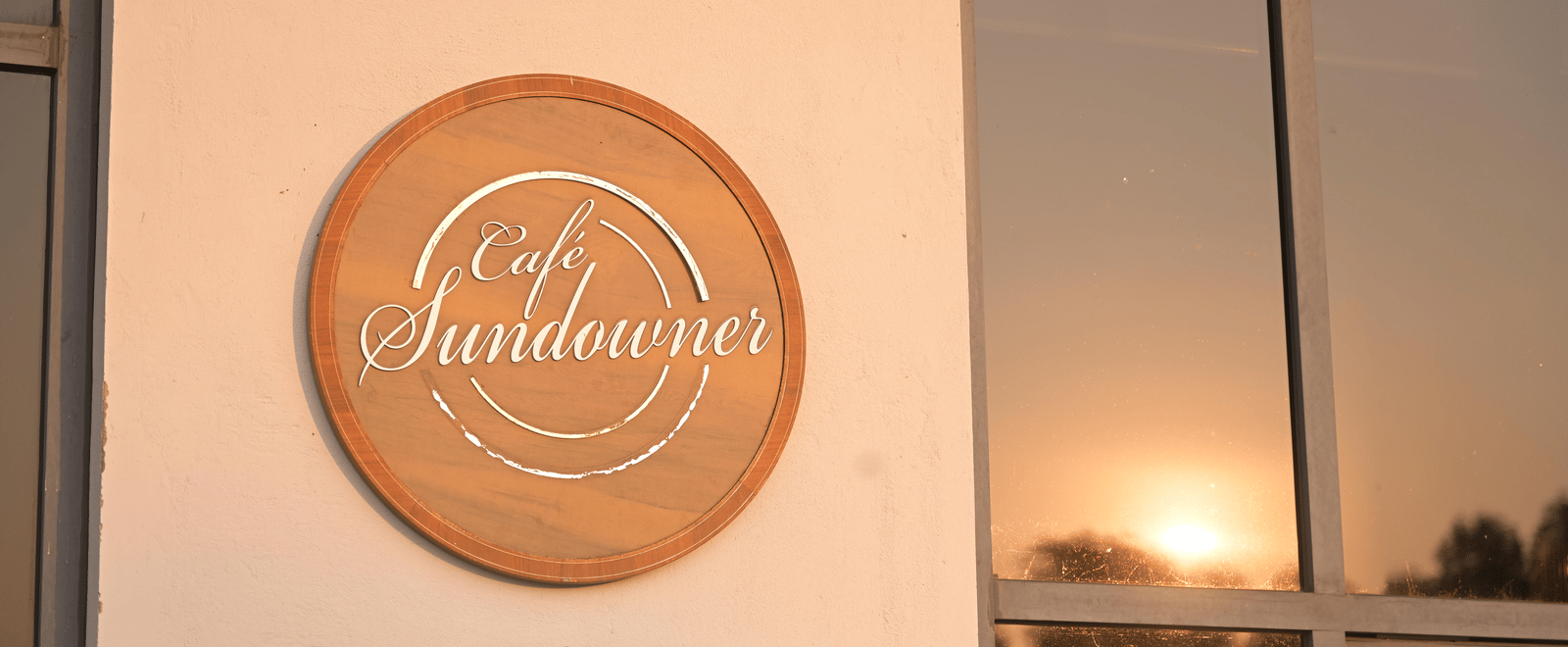 Close-up of the Sundowner name plaque mounted on the building wall at Hotel Sonar Bangla Mayapur.