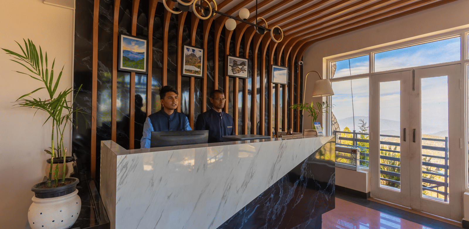 A view of the elegant reception desk with warm wooden paneling at Himalayas Resort By The Lake Hill, Mukteshwar.
