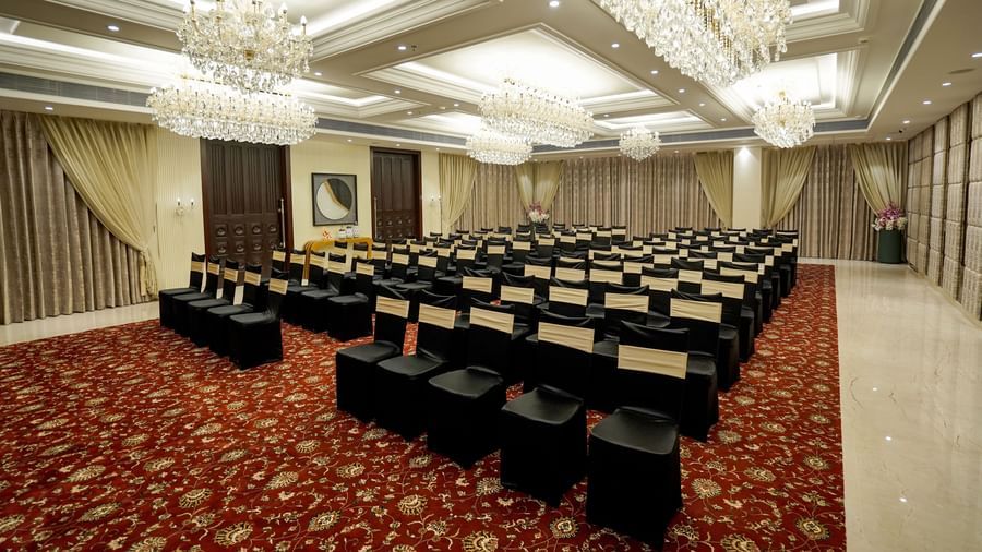 A wide angle shot of the Ballroom at M2 Square by Monday Premium with chairs arranged in a classroom setting with chandeliers hanging from the ceiling.