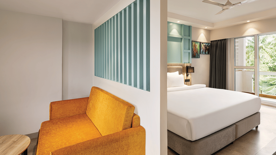 Hotel room with a king size bed, seating area and private balcony.
