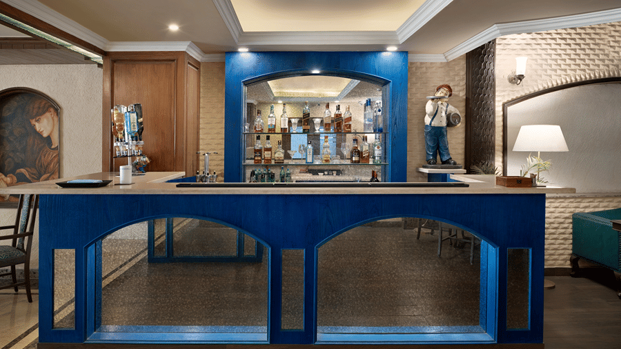 A service counter standing in an indoor dining area with warm wall lights at Ramada by Wyndham Mussoorie Mall Road.