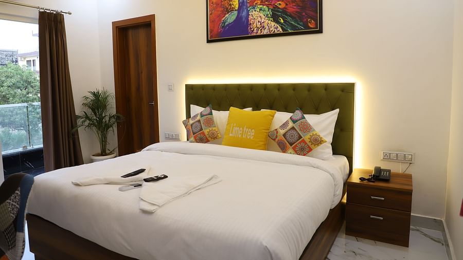 A room featuring a well decorated bed side drawer wall oainting and an AC - Opulent Inn