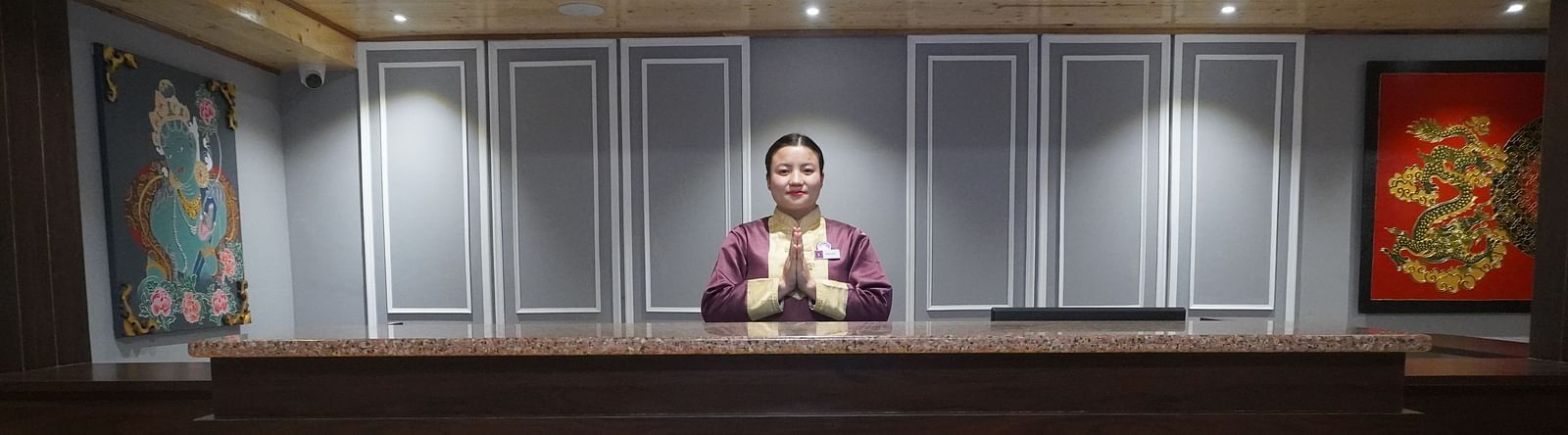 a woman welcoming at the reception desk at Sumitel Pelling, Geyzing