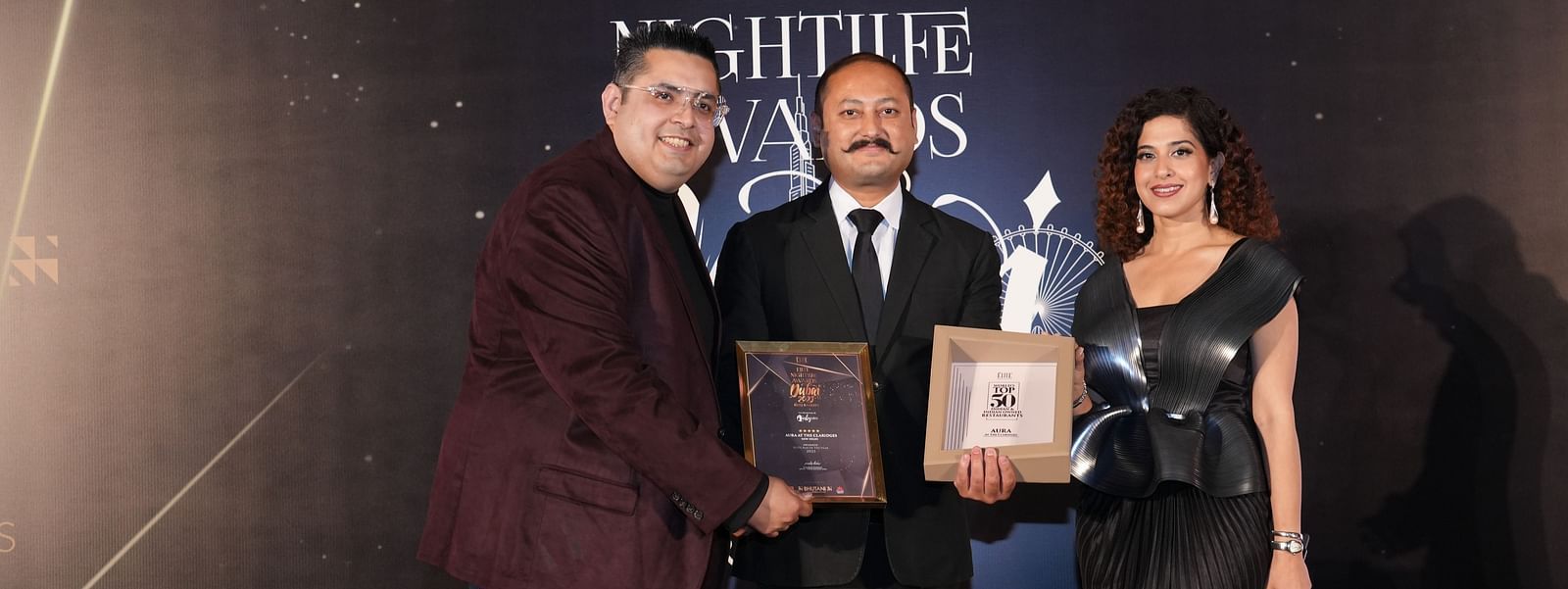 Three individuals with awards posing for photo Elite nightlife award at The Claridges New Delhi - Claridges Collection