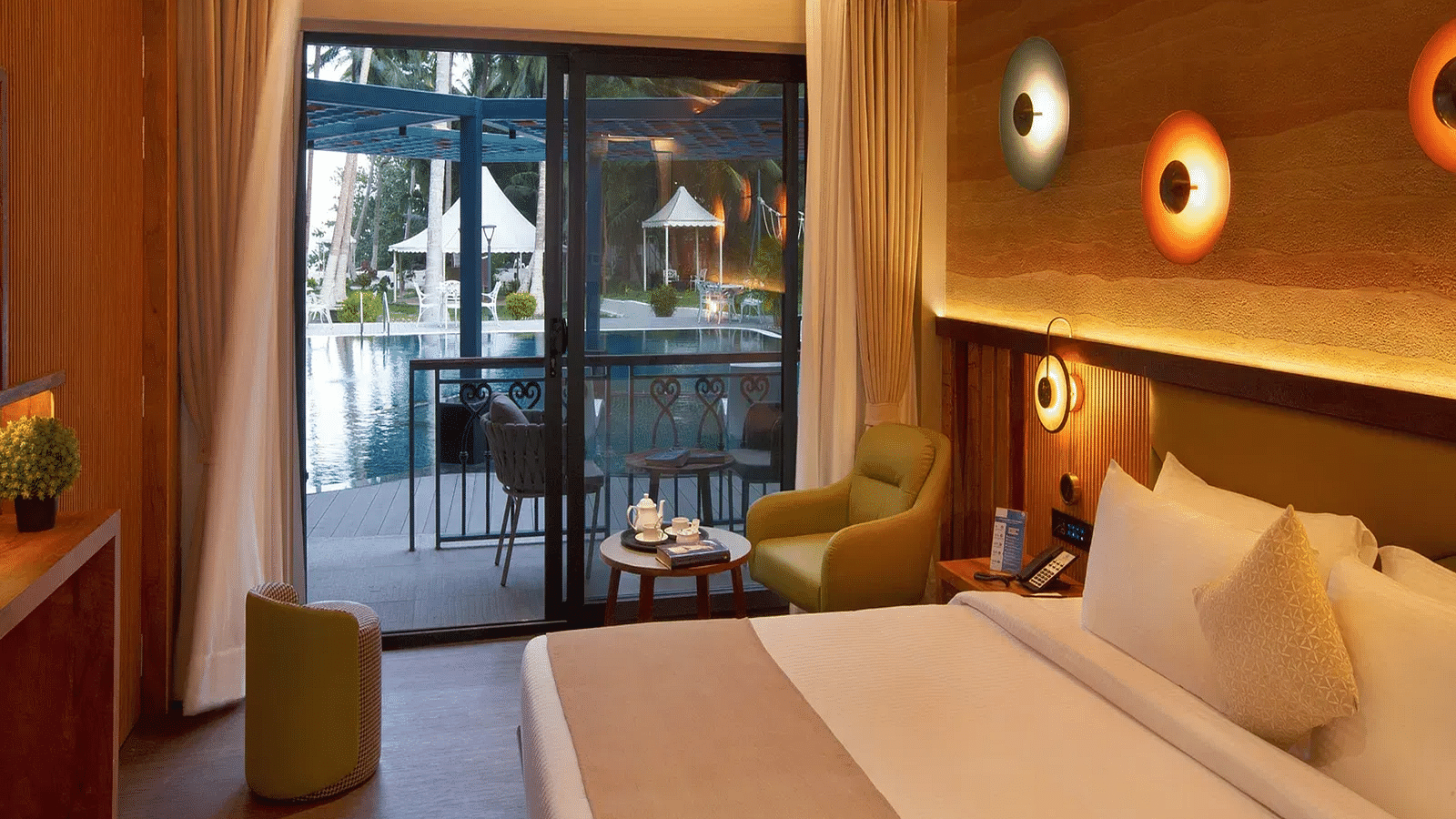 Coral Sapphire at Coral Reef Resort and Spa in Havelock featuring a plush bed and a seating space next to it with the door to the outdoor lounge area beside it  