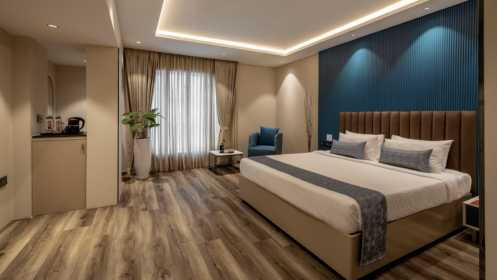  A modern room at the Citrine Hotel featuring a bed, a TV, and accent lighting on the ceiling and walls.