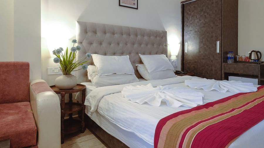 A cosy bedroom featuring a padded headboard, bed, and warm lighting – The Verda de Miranda Resort.