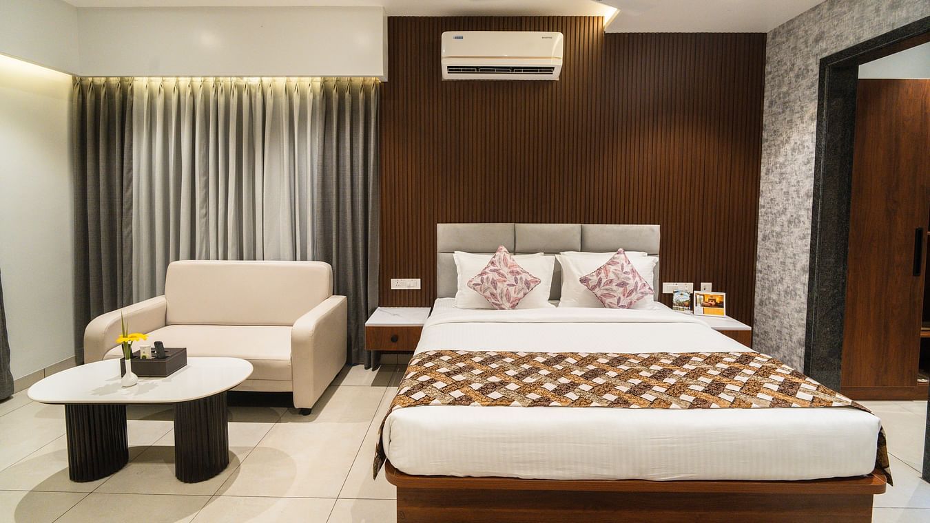 An image of a bedroom with a large bed, a sofa and a coffee table - MGM Whispering Meadows