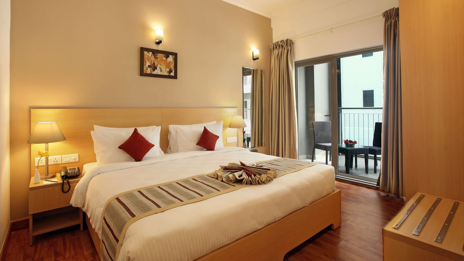 A double bed with side tables and lamps inside Deluxe Room - Starlit Suites, Kochi