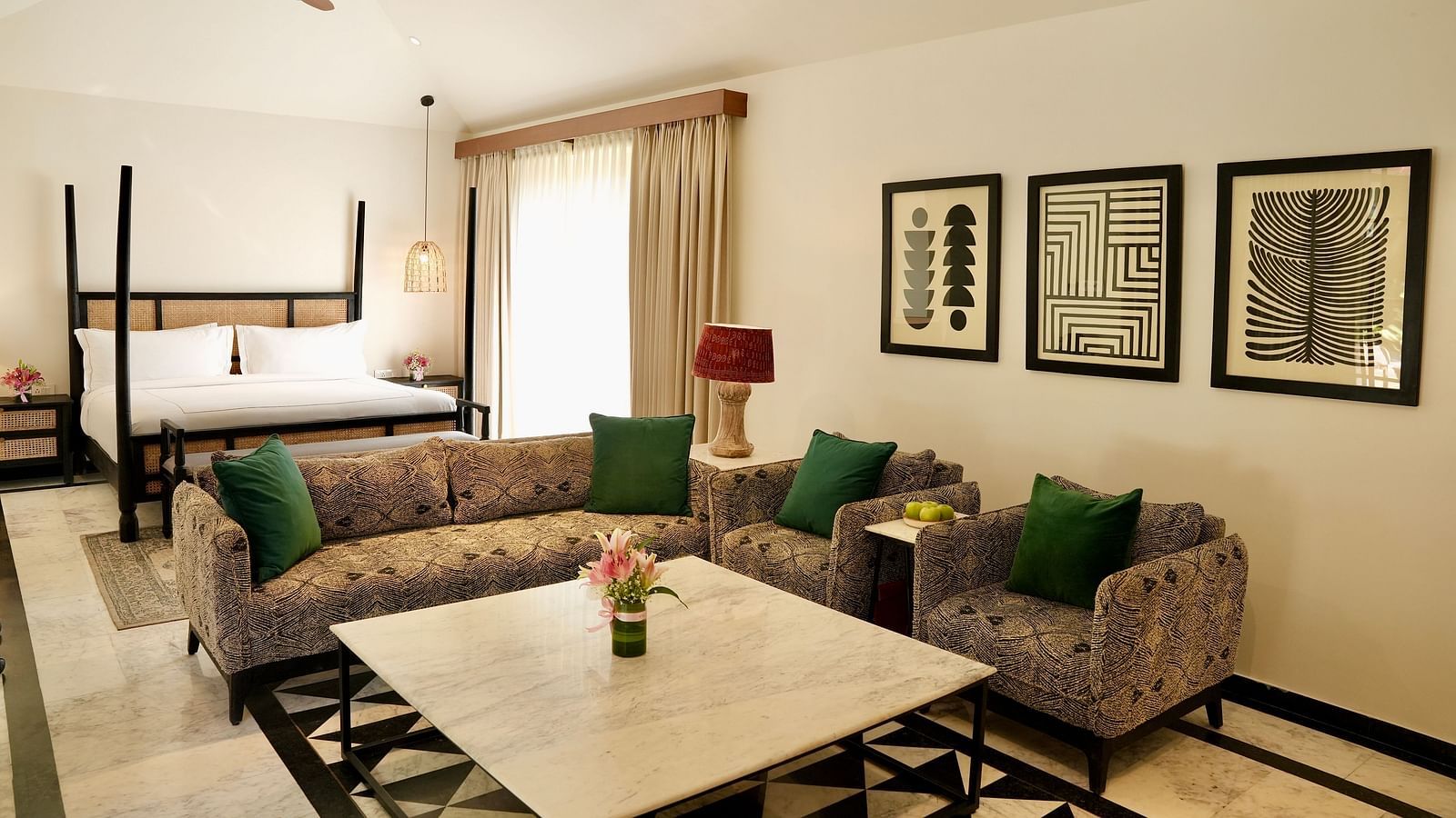 A room with a bed and a seating area adorned with frames at Surpura Bagh.