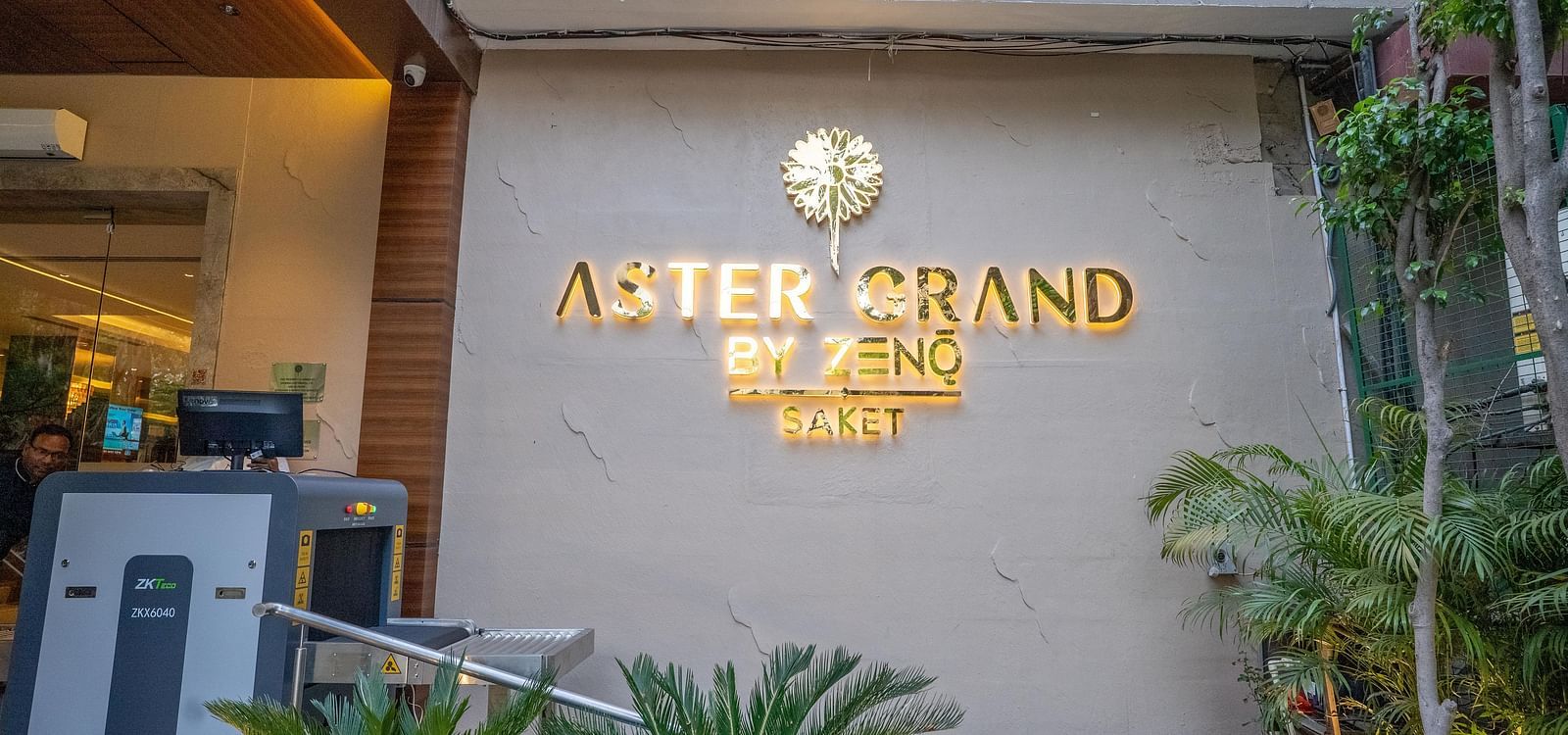 Facade view of ASTER GRAND BY ZENQ SAKET hotel with plants in the front.