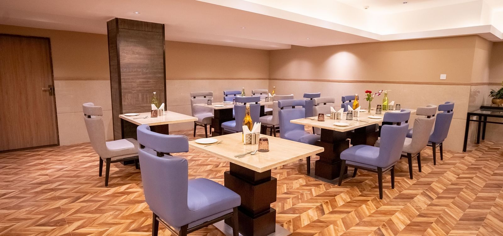 Nutmegg restaurant with neatly arranged tables and chairs at ASTER GRAND BY ZENQ SAKET.