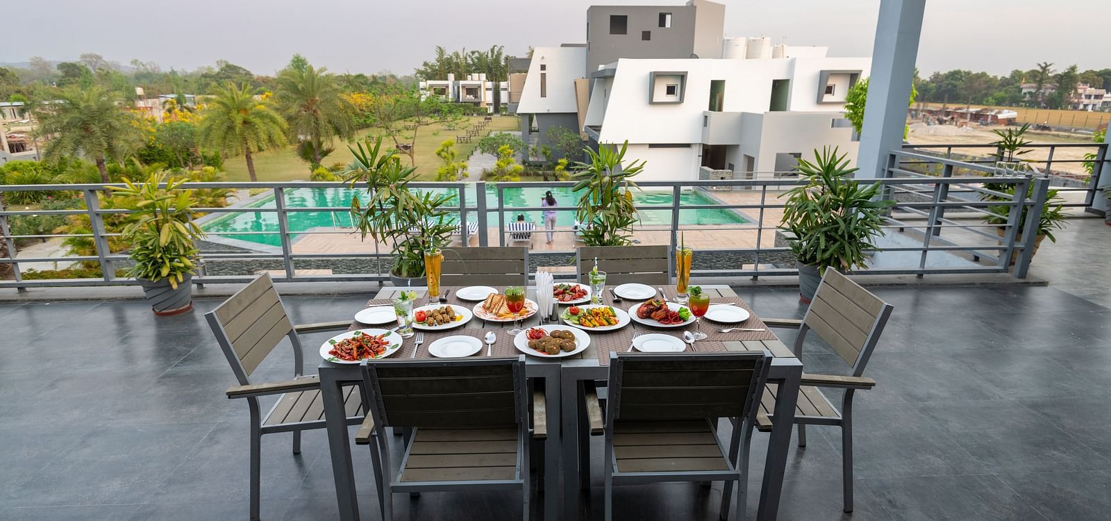 A table for six set with a variety of dishes on the terrace at DLS Forest Vines Resort.