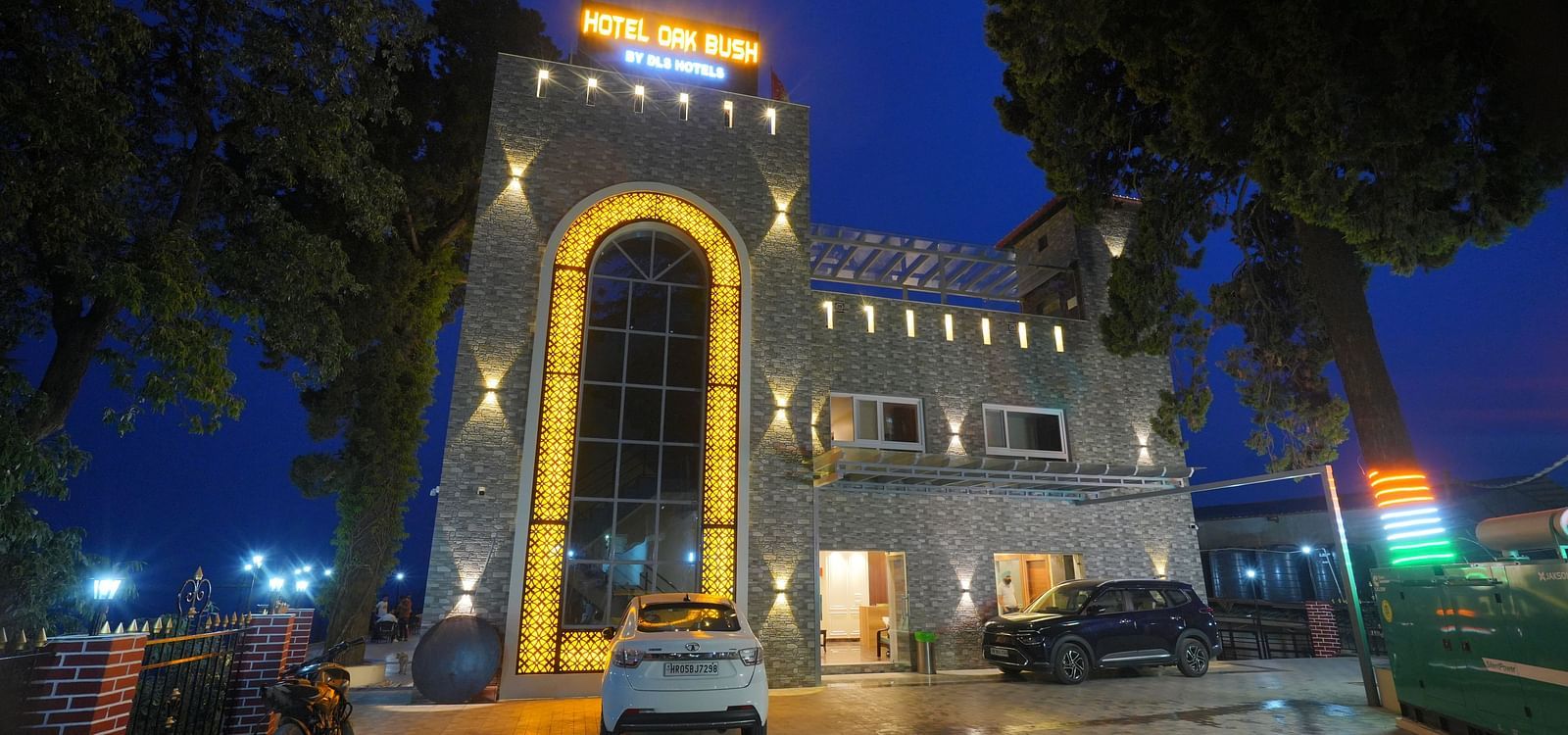 Facade view at night of DLS Oak Bush, Mussoorie with car parked outside.