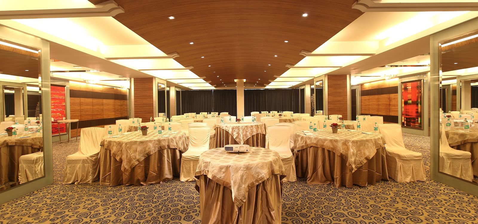 Image of Amber hall at Mirage featuring a stylish decor with brown round tables and chairs | Mirage Hotel