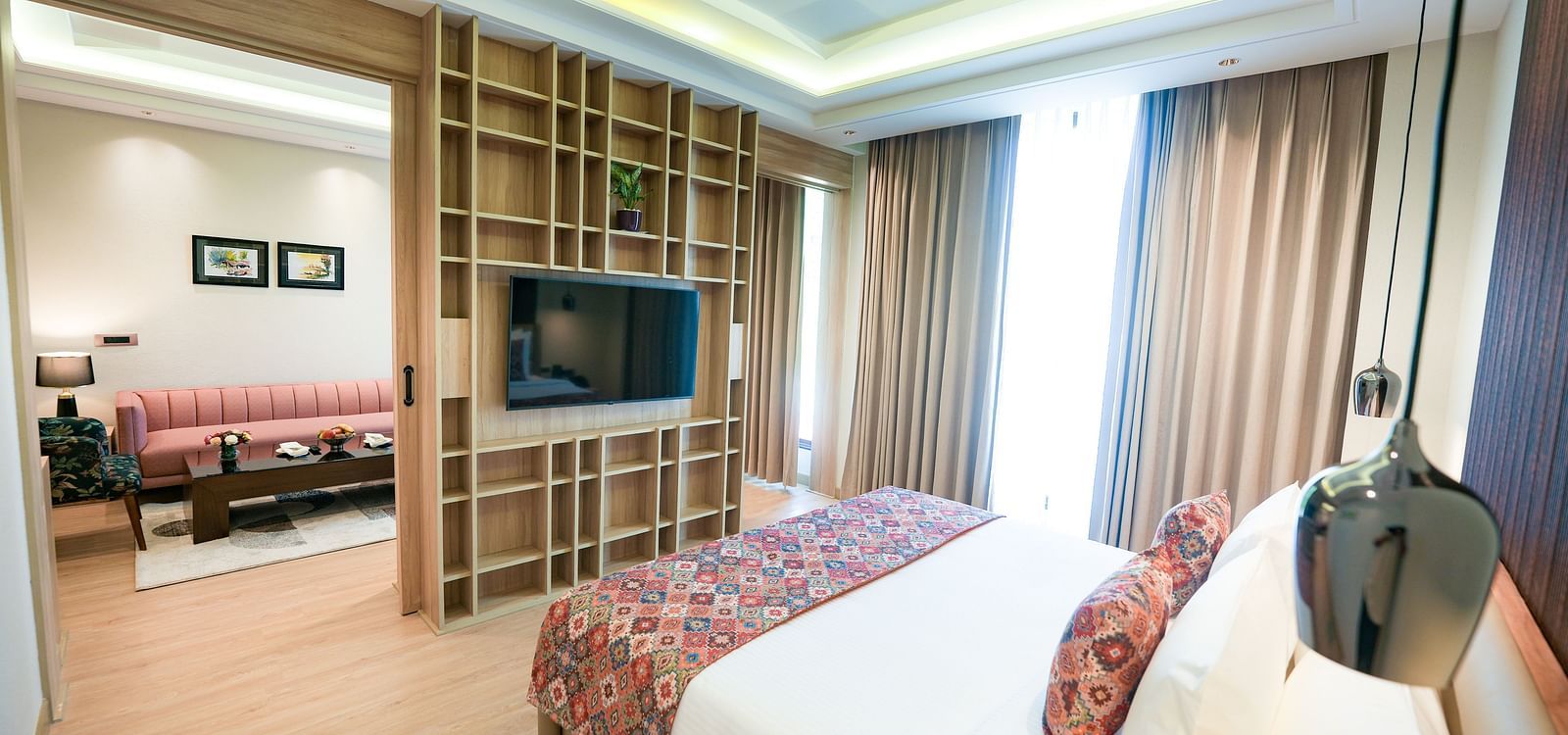 An image showcasing a bedroom of a suite in Kangra in the foreground, with the living area visible in the background - NAMAMI BY ZENQ BANKHANDI