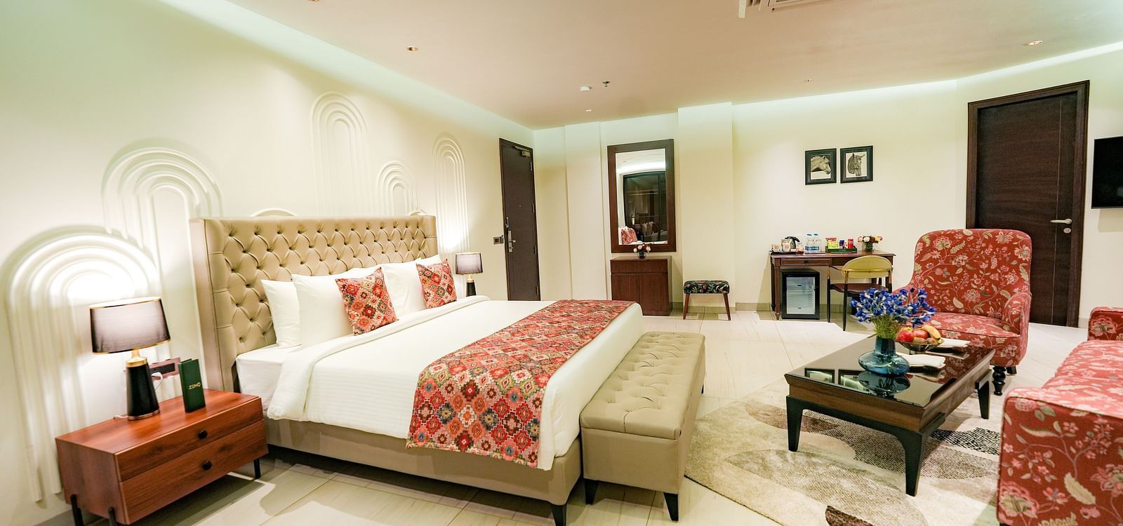 A large suite in Bankhandi featuring a queen size bed with a bed bench, a night stand with a lamp, and cosy furniture - NAMAMI BY ZENQ BANKHANDI