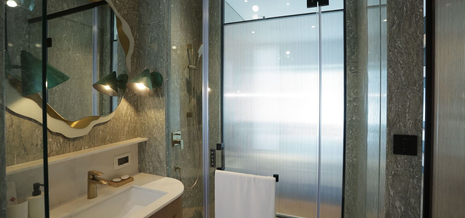 Luxurious bathroom at Regency Hotel, Mumbai featuring modern glass shower, marble finishes, elegant lighting and premium amenities for a sophisticated stay.
