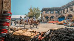 People riding a camel standing outside a market during a clear day