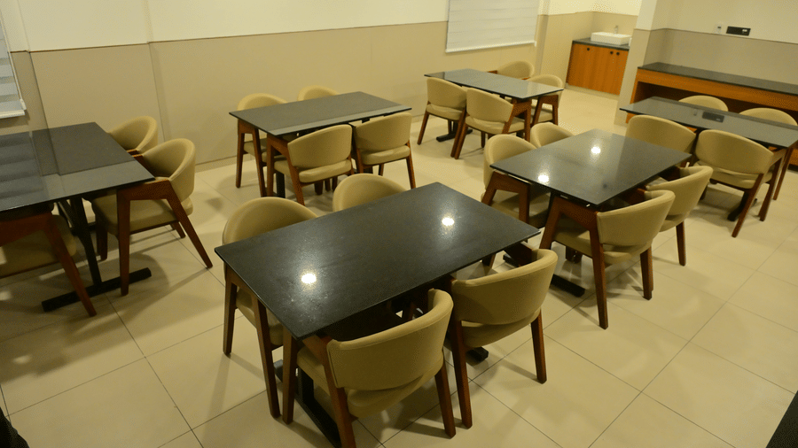 Casual dining area at Bhavanis Vista By Icon Hosur with neatly arranged tables and chairs in a well-lit space.