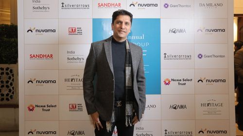 An image of a man posing in front of a sponsored brands board in Annual Golf celebration at Heritage Village Resorts & Spa