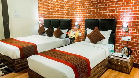 An image of the deluxe room with twin bed, bed side tables, and other modern amenities - Ecotel Tin Tin, Bijanbari