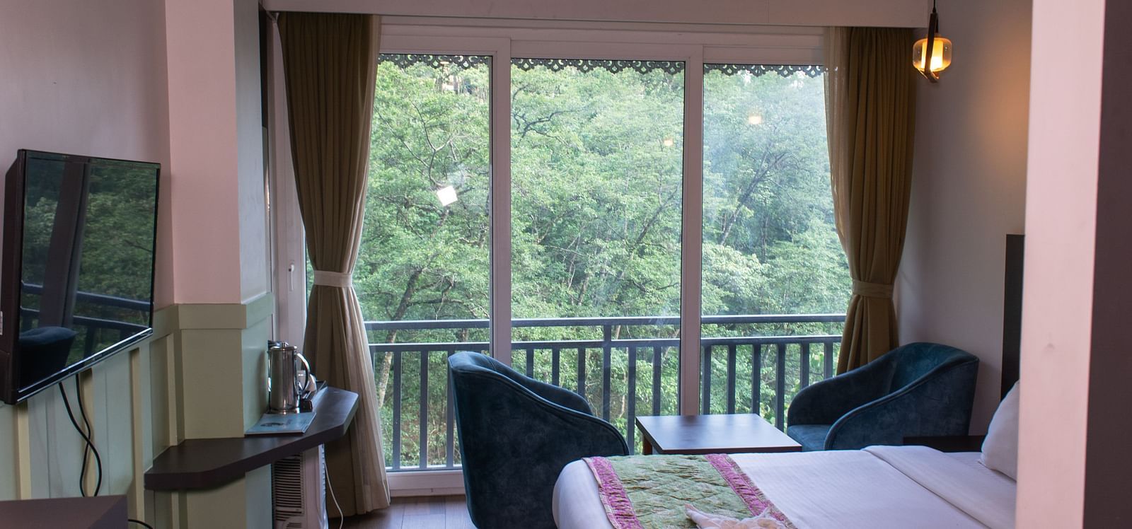 Image of premuim room with bed and sitting arrea overooking the lush greenery outside at  Avianna Ganagtok Resort and Spa