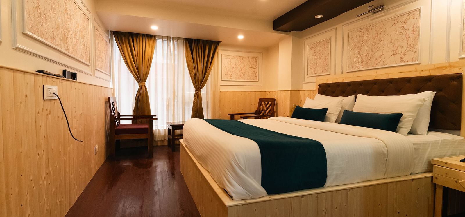 an image of a bedroom with a window covered by curtains at Avianna New Mandala Hotel & Spa, Darjeeling.