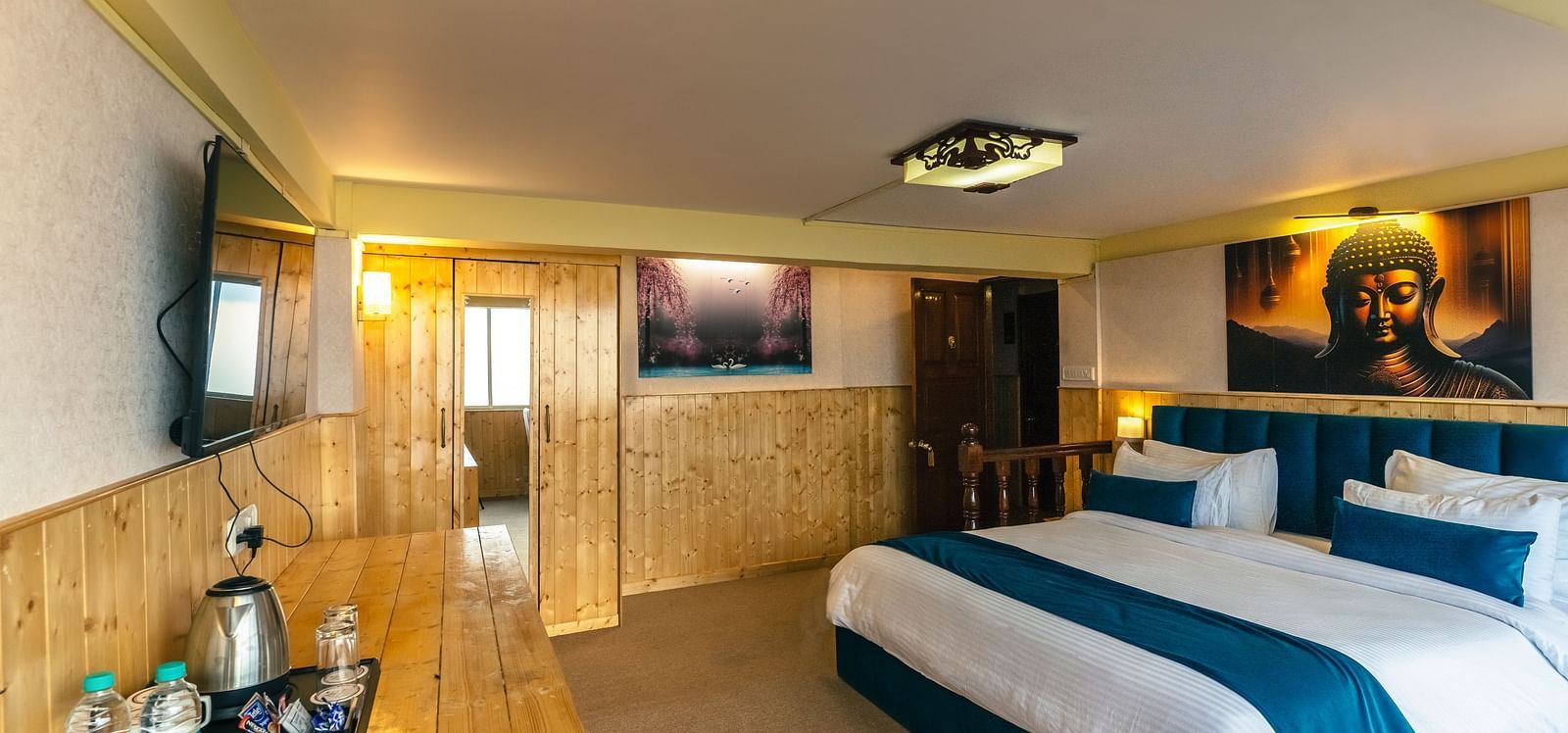 Spacious Premium Room featuring a king size bed and wooden furnishings at Avianna Seven Seas, Darjeeling.