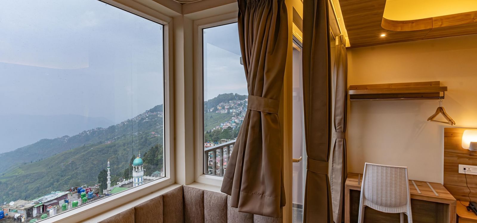 image of the premium room with a huge window exposing serene mountain views at The Soma Hotel by Avianna Group, Darjeeling