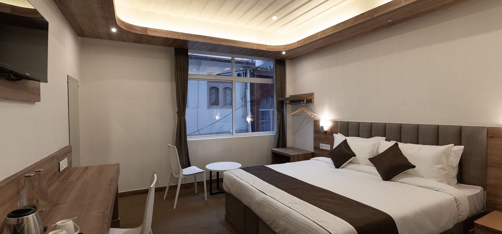 image of the Standard room with a king size bed and a window in the corner at The Soma Hotel by Avianna Group, Darjeeling