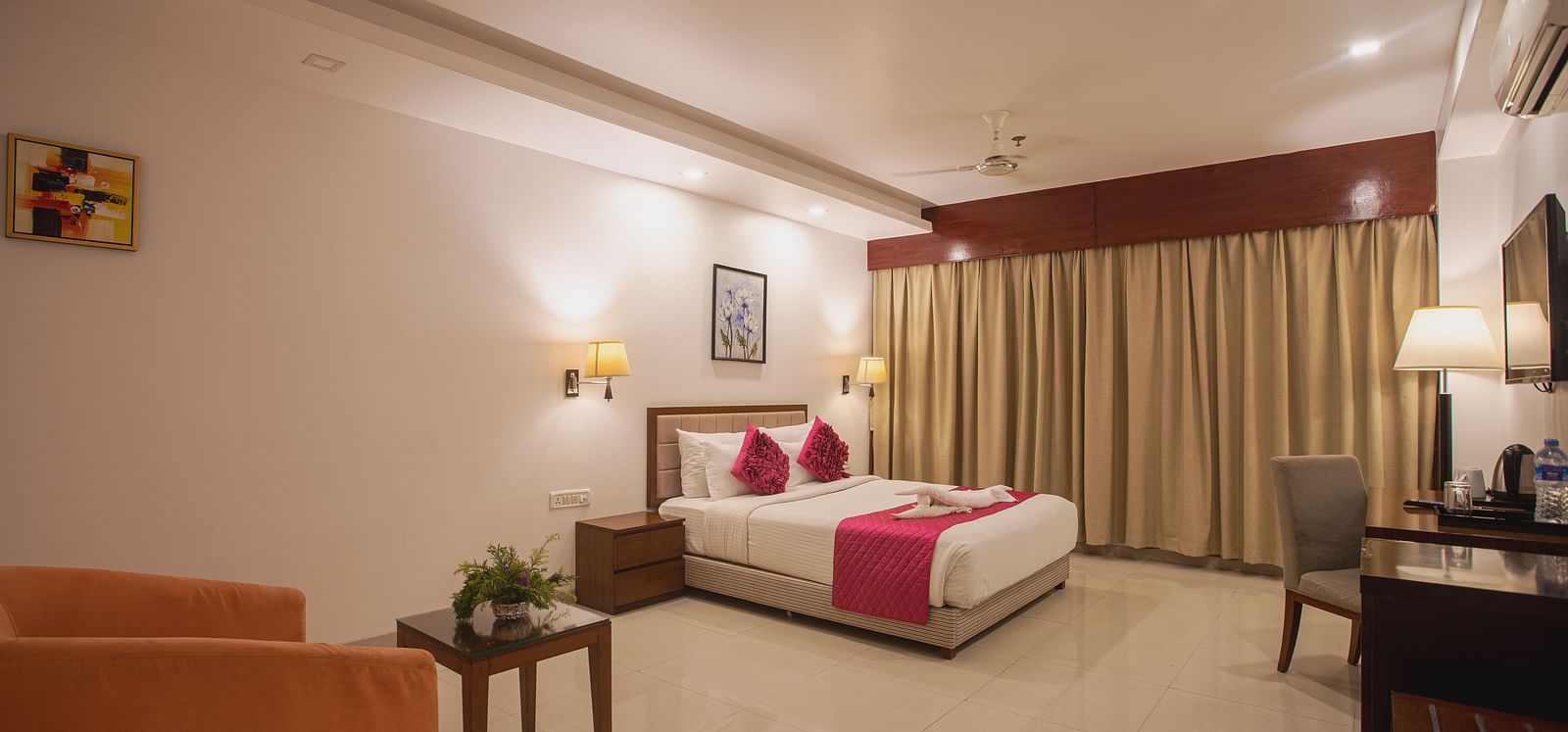 Comfortable hotel room at Diamond Palace Lords Plaza with a double bed, seating area, work desk, and a large window.