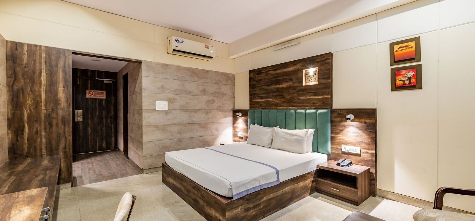 Extended view of the Maharaja Deluxe Room at Hotel Highway King, Behror, furnished with a double bed, air-conditioning, a work desk and seating area for two.