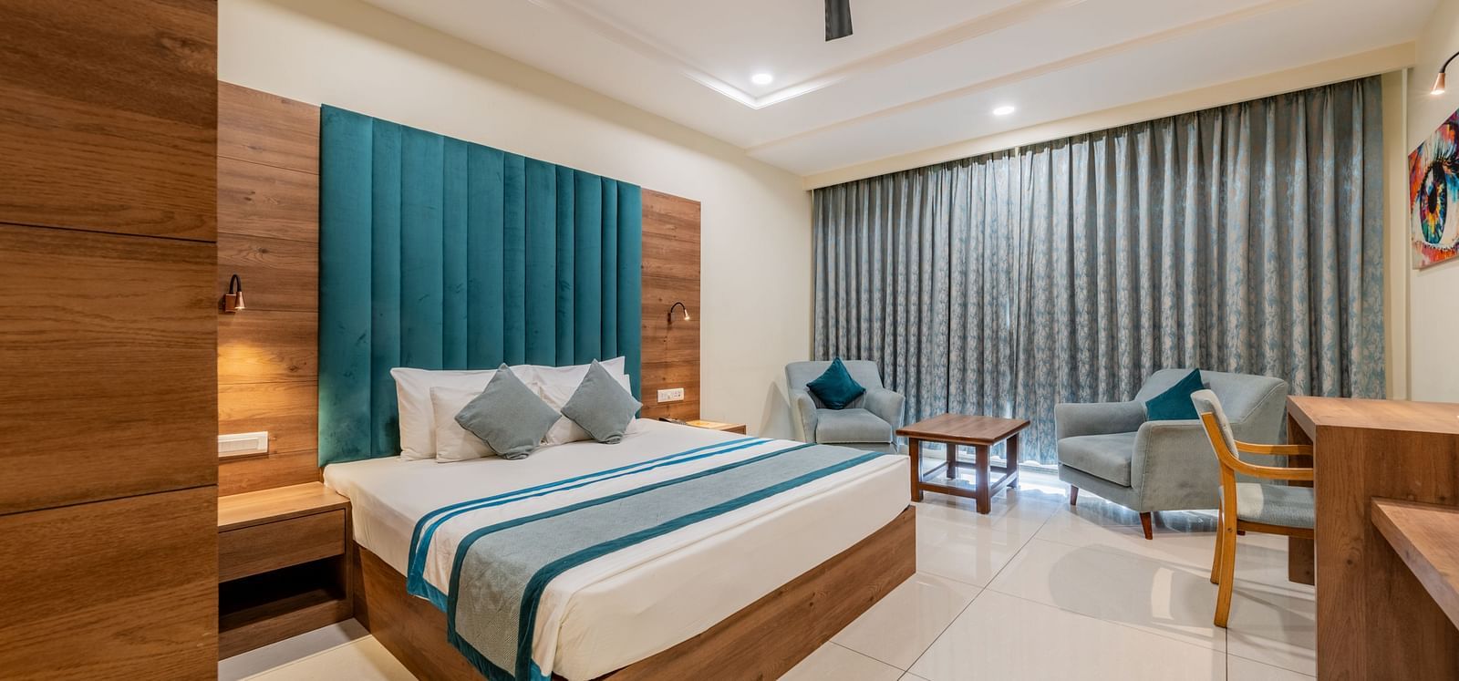 Spacious King size bed room with elegant design, writing desk, and seating area at Hotel Highway King, Bilaspur.