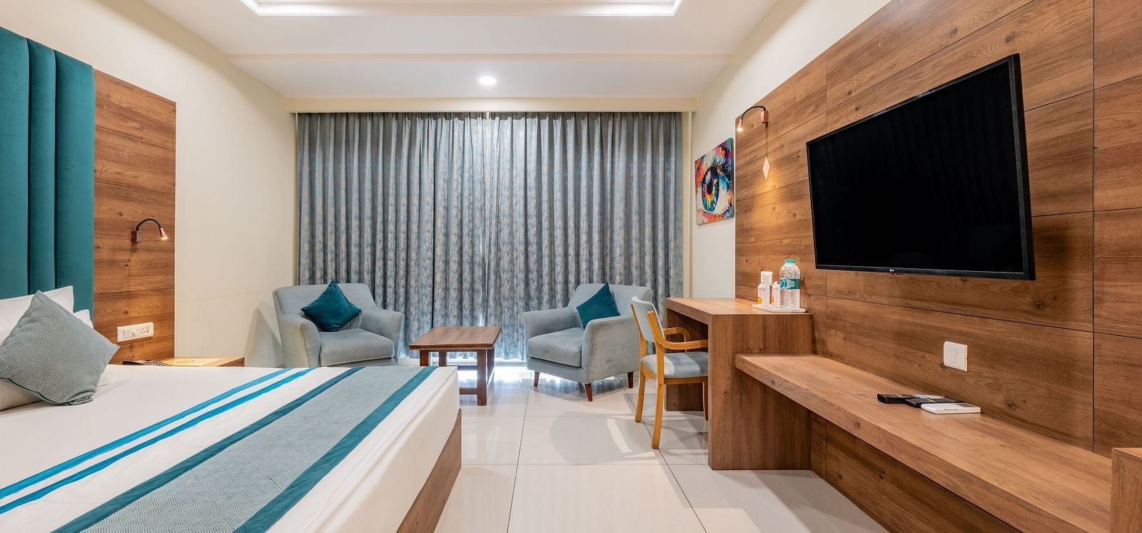 King size Bed Room with a flat-screen TV, work desk, and lounge area at Hotel Highway King, Bilaspur.