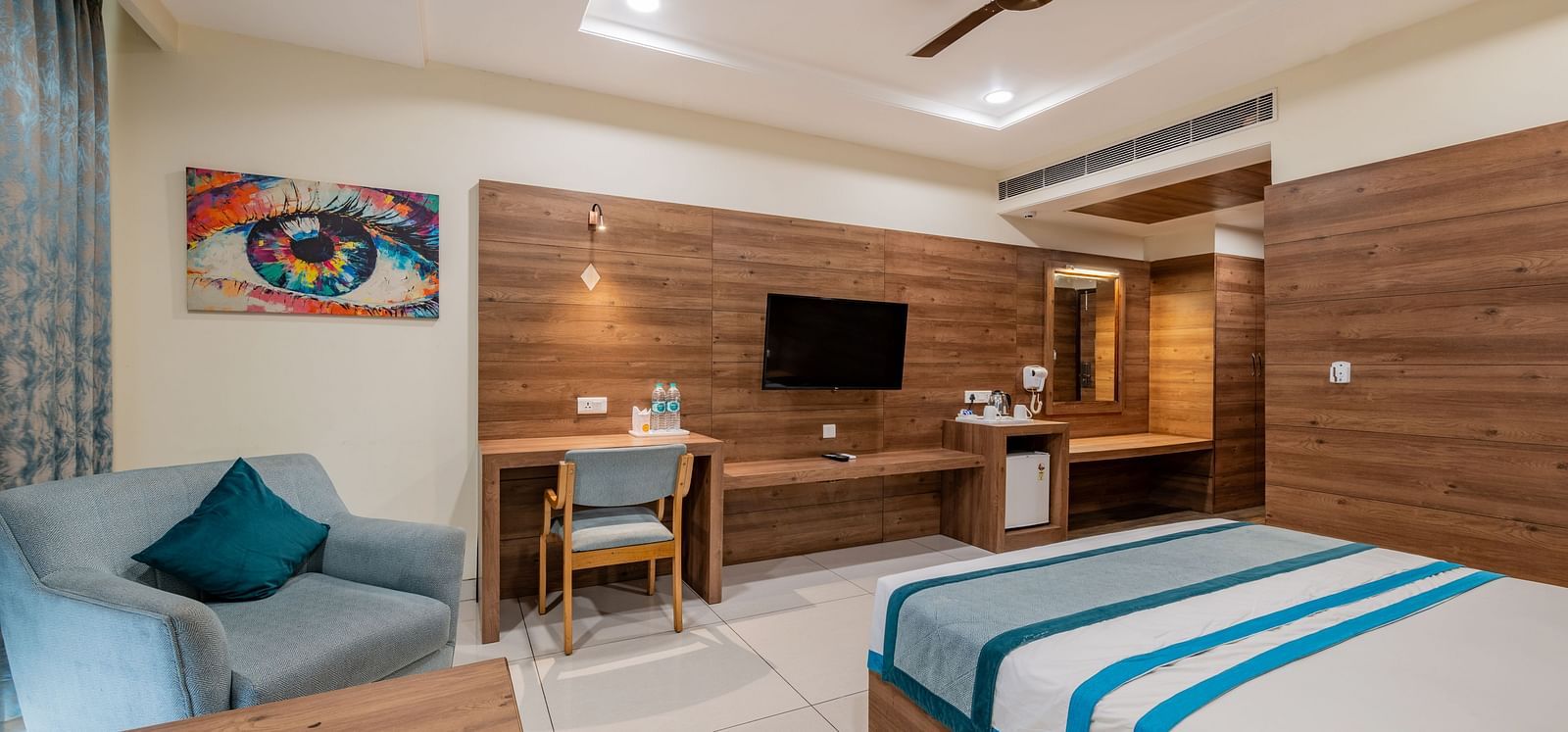 King size bed and cosy seating area in a modern room at Hotel Highway King, Bilaspur.