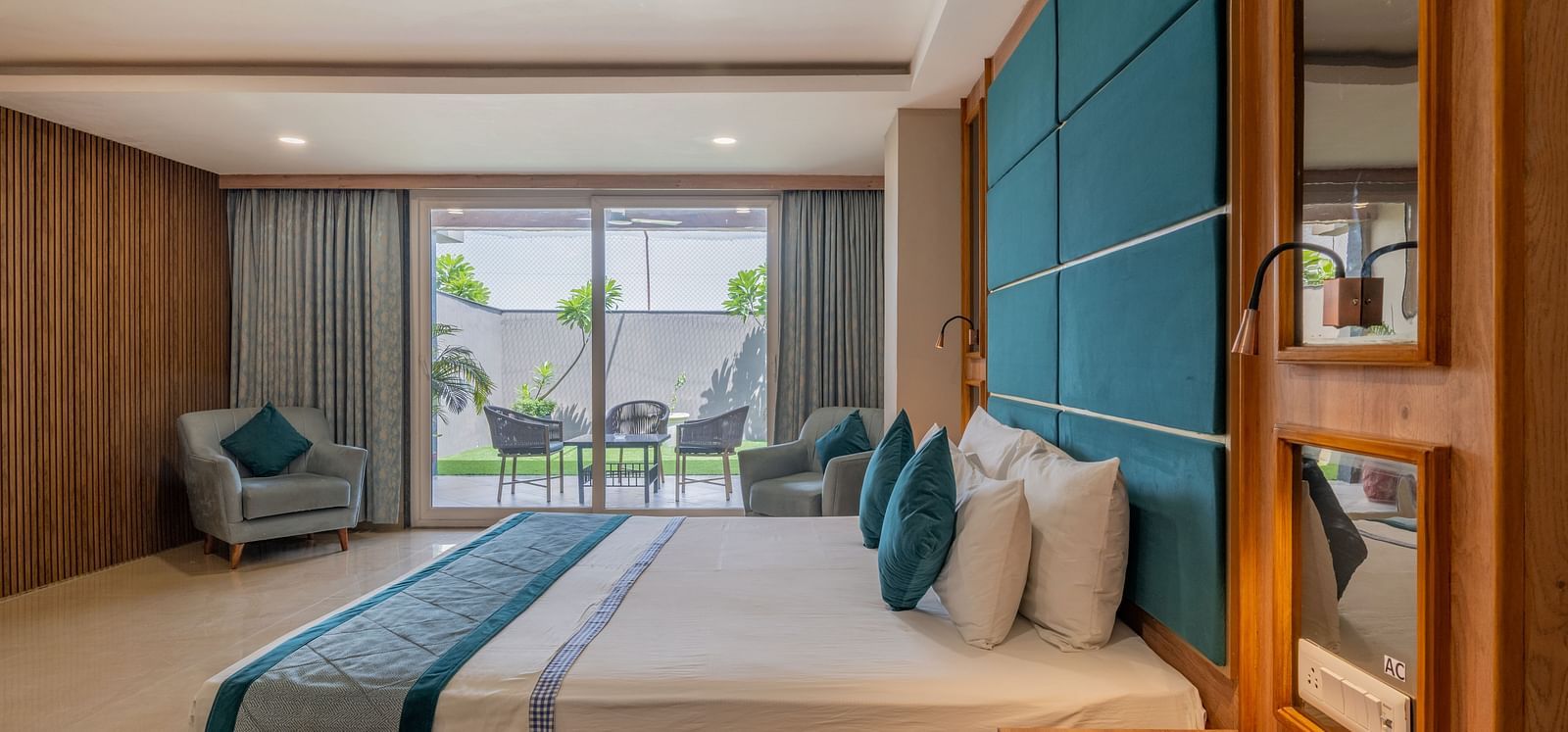 A well-appointed guest room with a large bed and a view of the outside area at Hotel Highway King Shahpura.