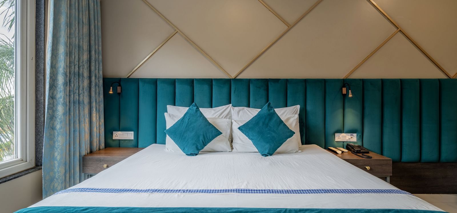 A well-appointed guest room with a king-sized bed and teal accents at Hotel Highway King Shahpura.