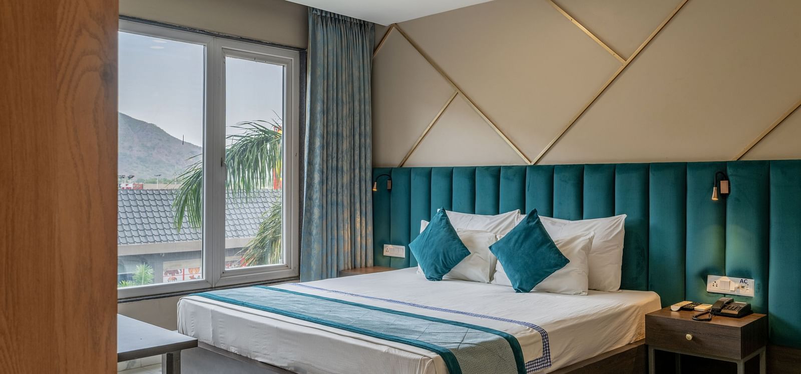Another view of a stylish guest room featuring a comfortable bed and modern decor at Hotel Highway King Shahpura.