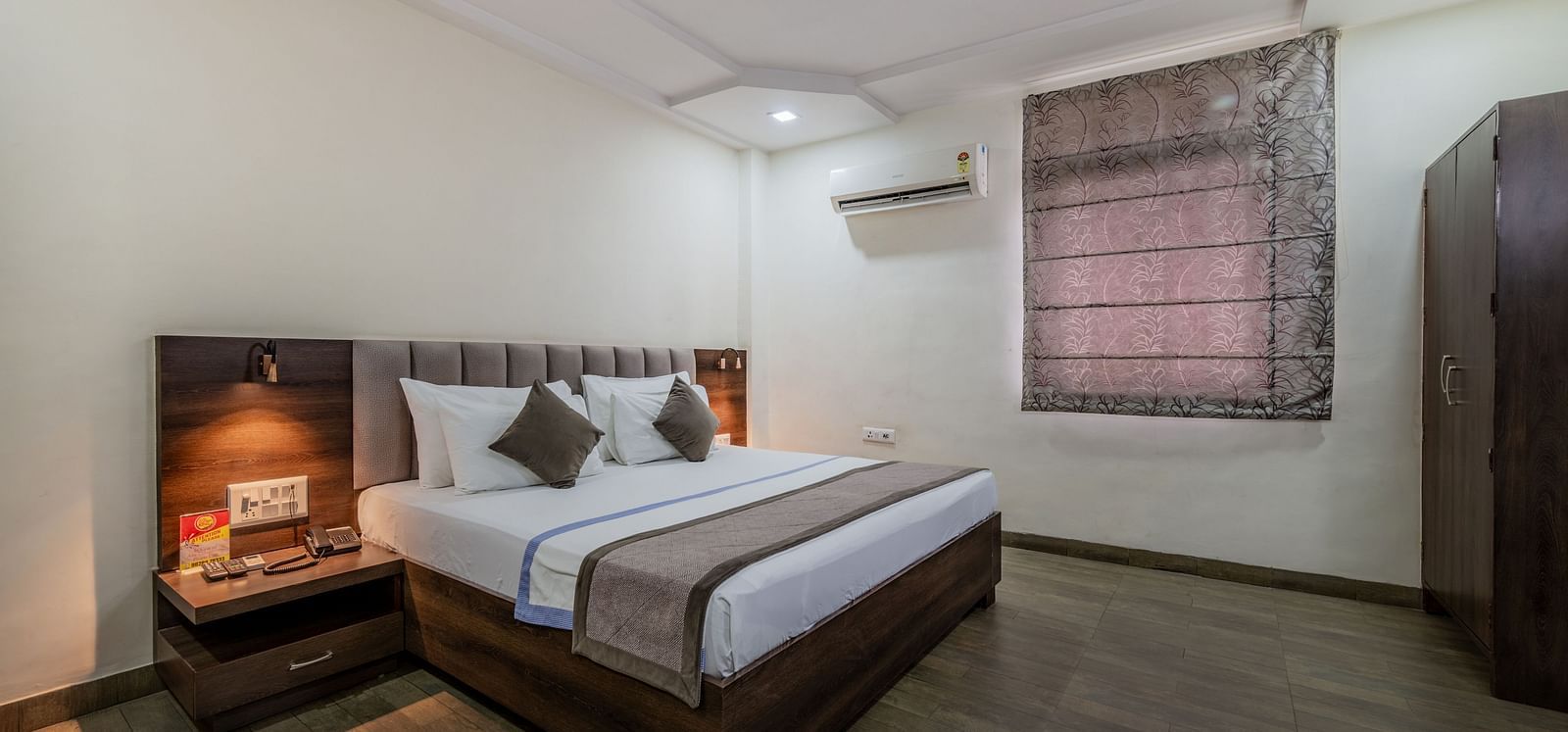 A bright guest room with a bed and a large window offering natural light at Hotel Highway King Shahpura.