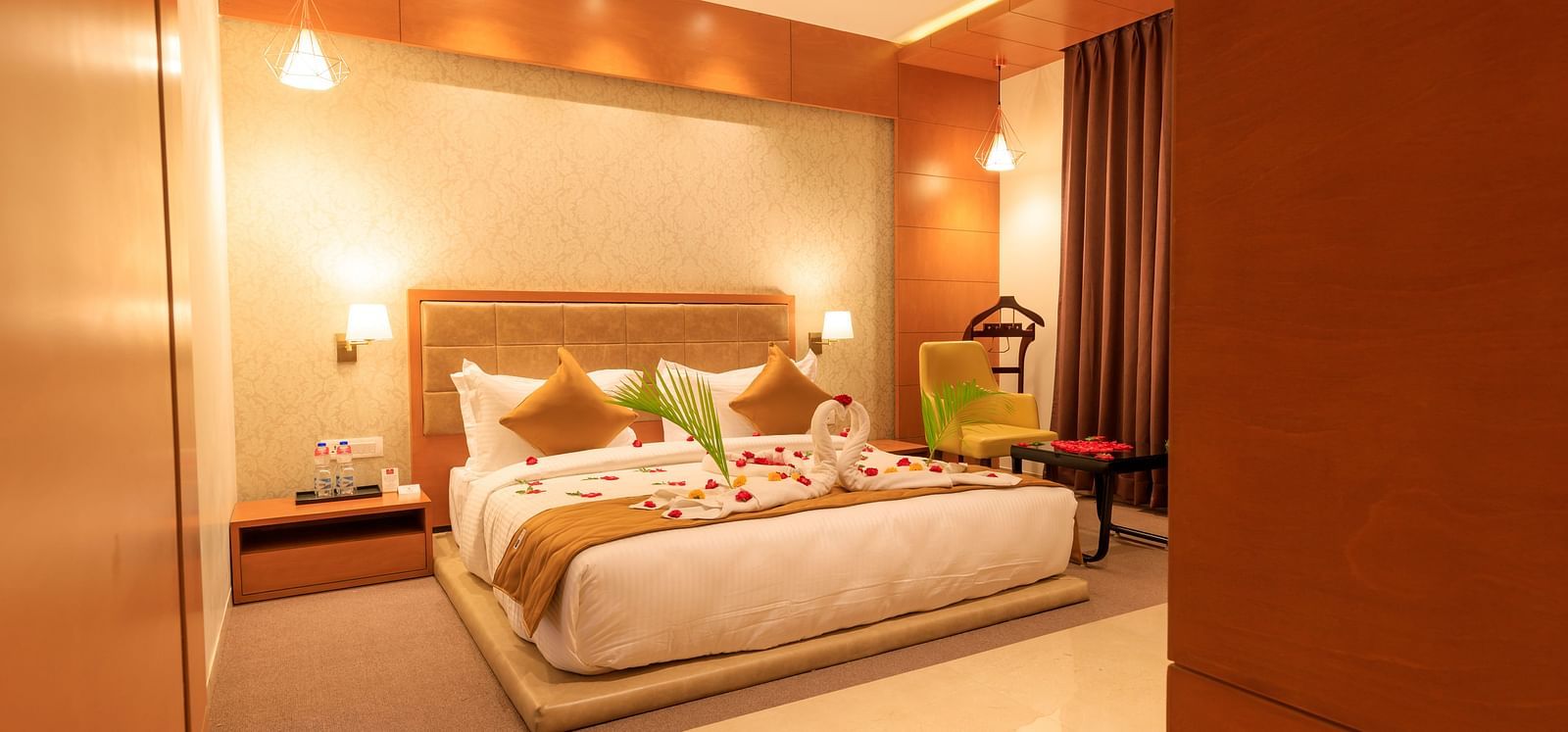 A warmly lit hotel room at Lords Eco Inn Apple Gate features a decorated double bed and bedside tables.