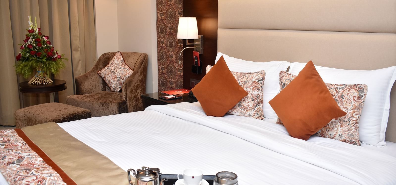 DSC 0726A well-appointed hotel room includes a bed and seating area at Lords Plaza Surat.