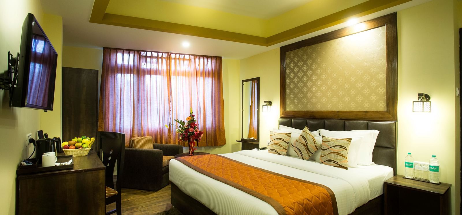 A hotel room at New Orchid Lords Inn Gangtok with a bed, furniture, and a window.