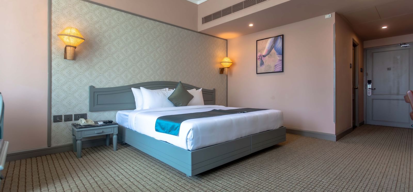  A contemporary guest room at Shilton International, Kochi featuring a large bed and tasteful furnishings.