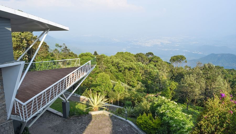 Spacious balcony offering a view of a bright, cloudy sky and distant horizon at Ibex Resorts, Coonoor (Tapas).